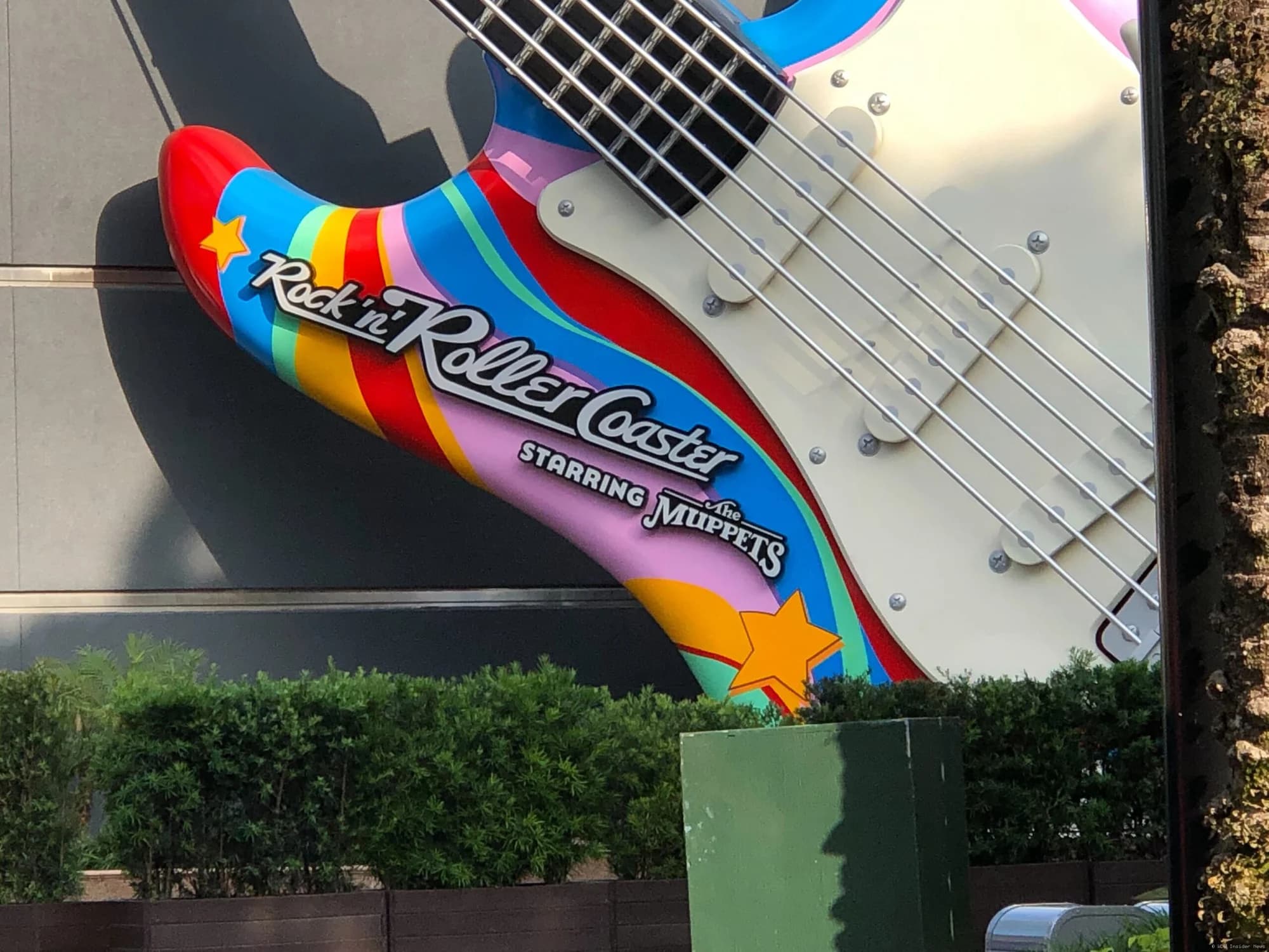 A large illuminated guitar sign at Walt Disney World's Hollywood Studios entrance, promoting the upcoming Rock 'n' Roller…