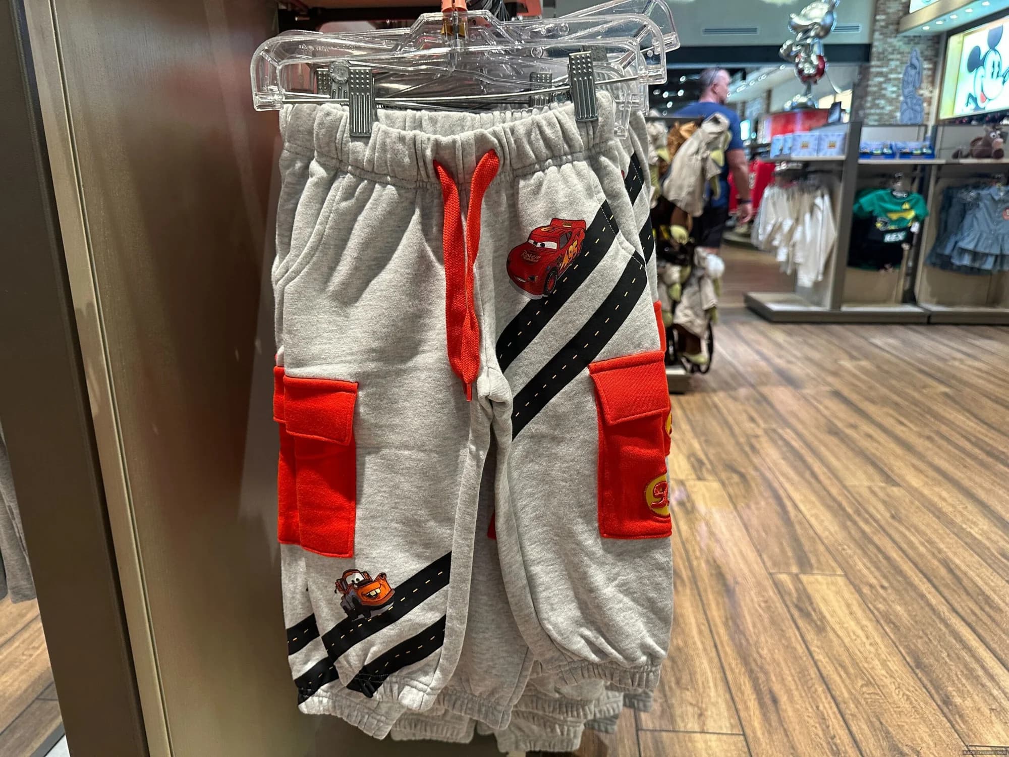 Lightning McQueen youth clothing displayed on mannequins or hanging in a Disney Springs or EPCOT retail shop