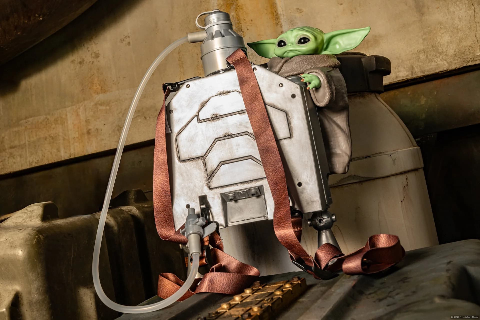 Grogu merchandise display featuring a droid-shaped bucket and jetpack-themed sipper cup at a Disney Parks retail location