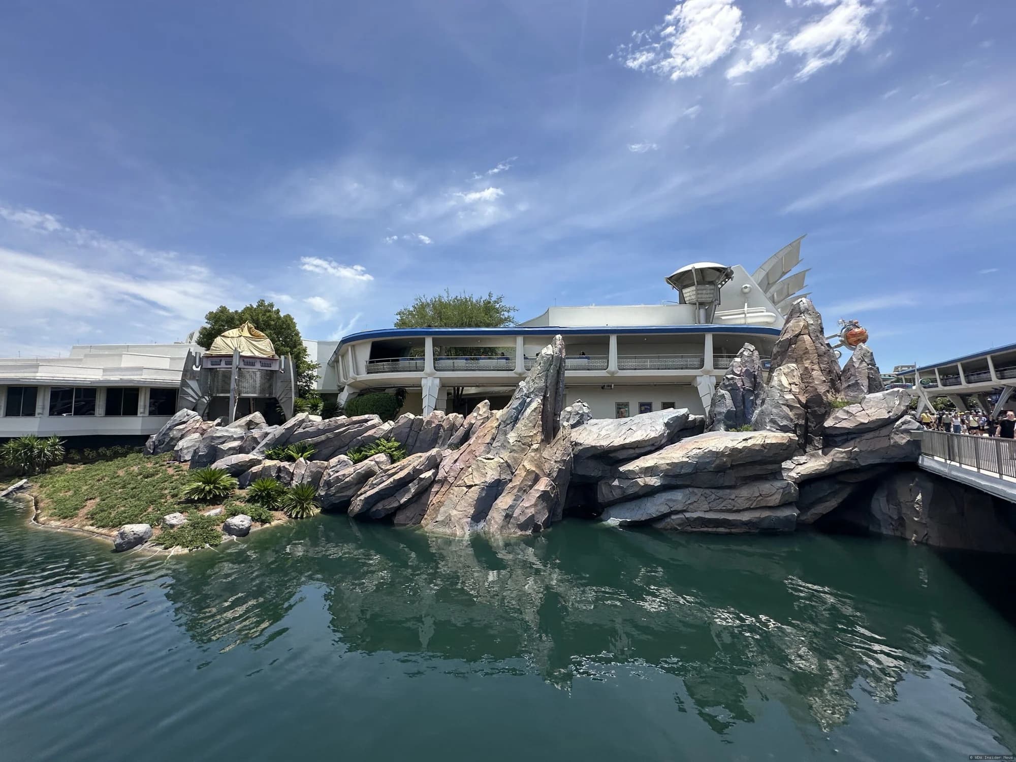 Demolition equipment removing a large futuristic tower structure in Tomorrowland at Magic Kingdom theme park