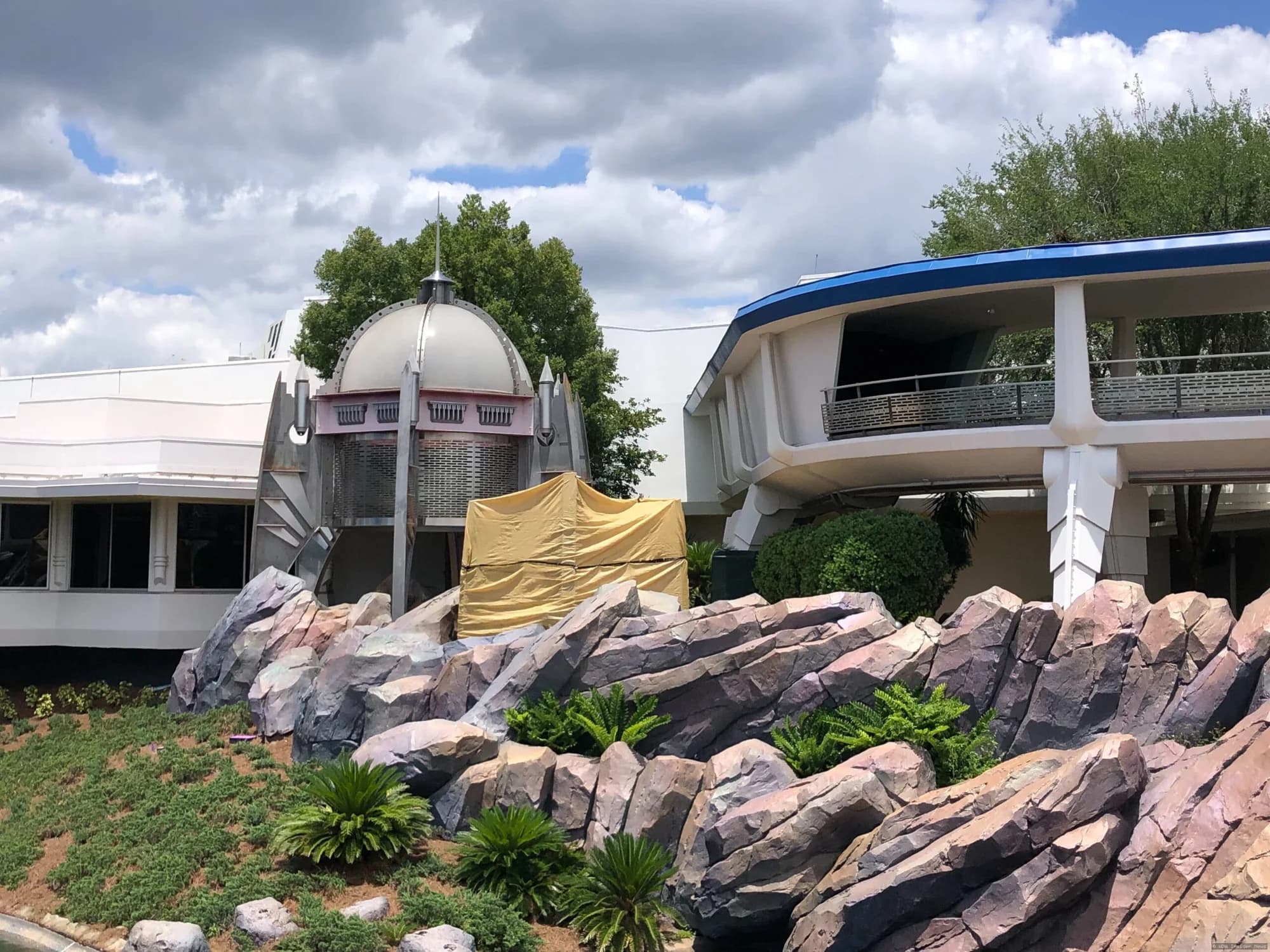 Demolition equipment removing a large futuristic tower structure in Tomorrowland at Magic Kingdom theme park