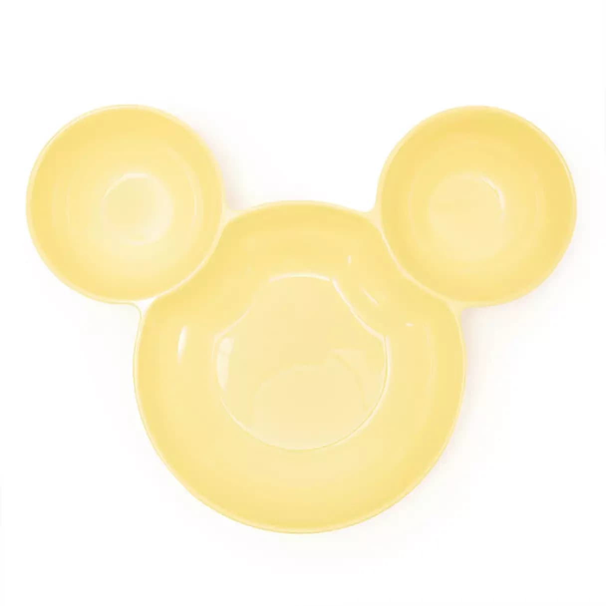 Mickey Mouse-shaped ceramic bowls and monorail-themed corn holders displayed on a kitchen counter