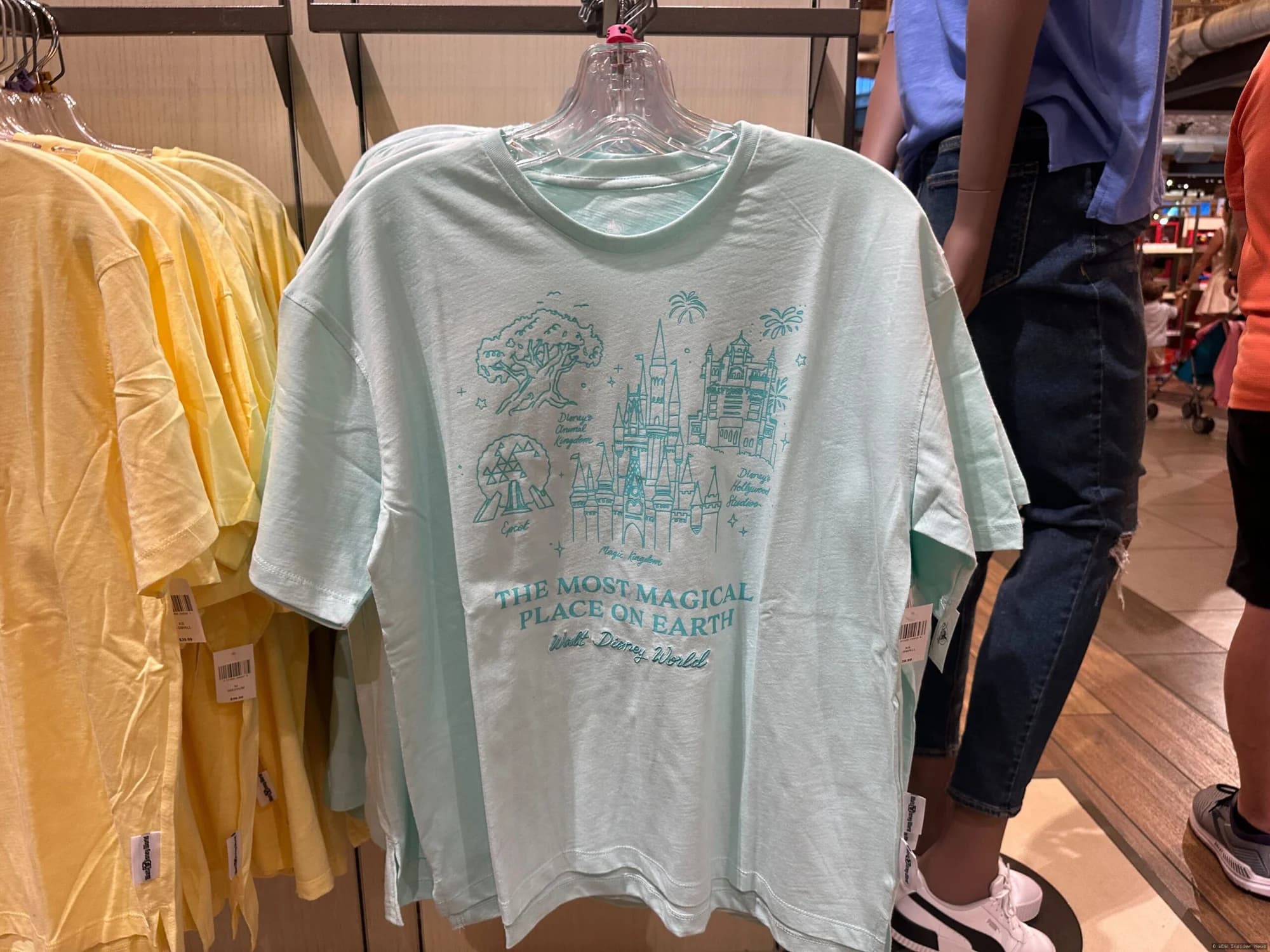 Four Walt Disney World theme park icons displayed on t-shirts in different colourways at World of Disney shop