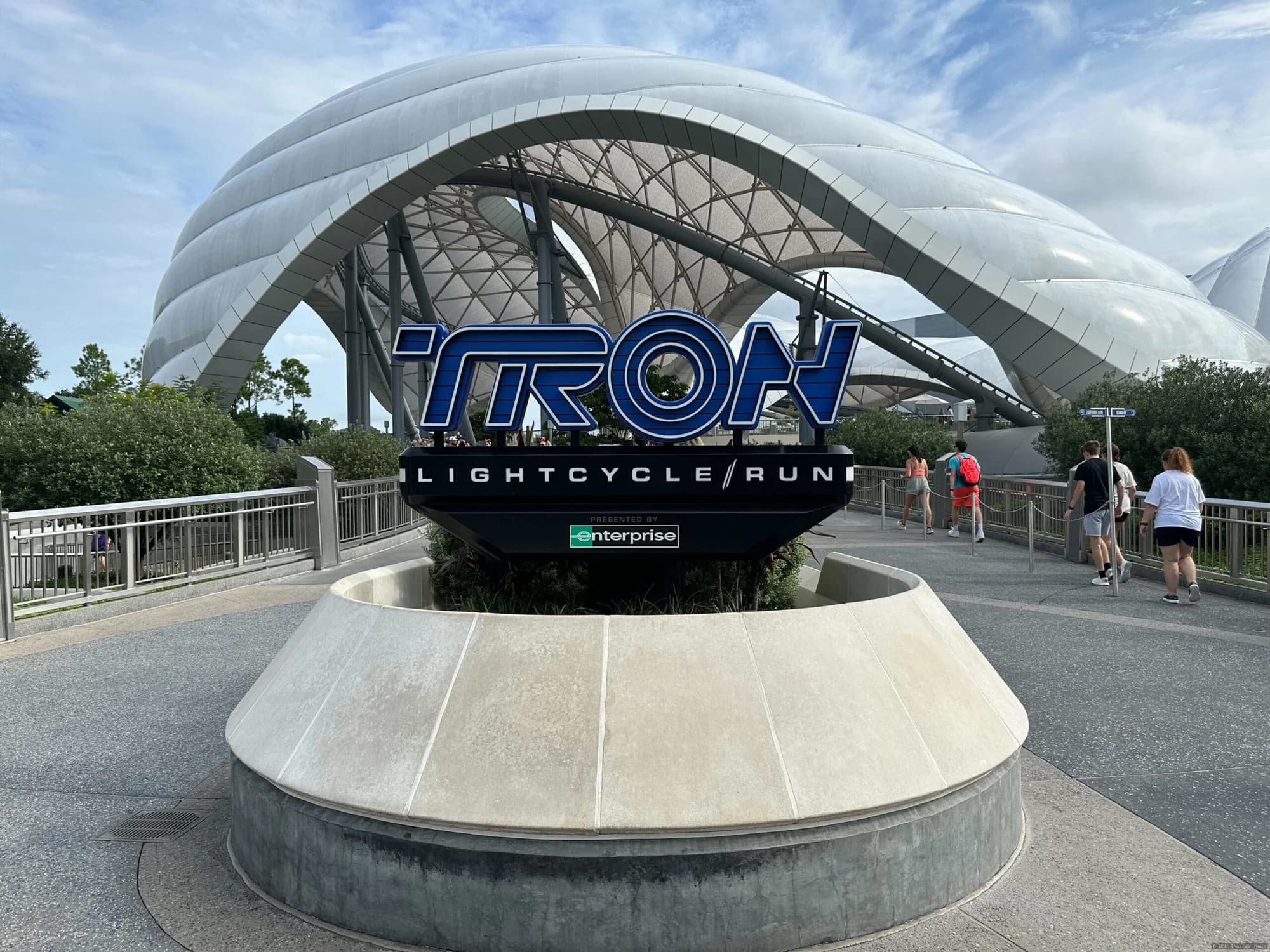 Visitors queuing together inside a dimly lit corridor at Magic Kingdom's TRON or Space Mountain attraction