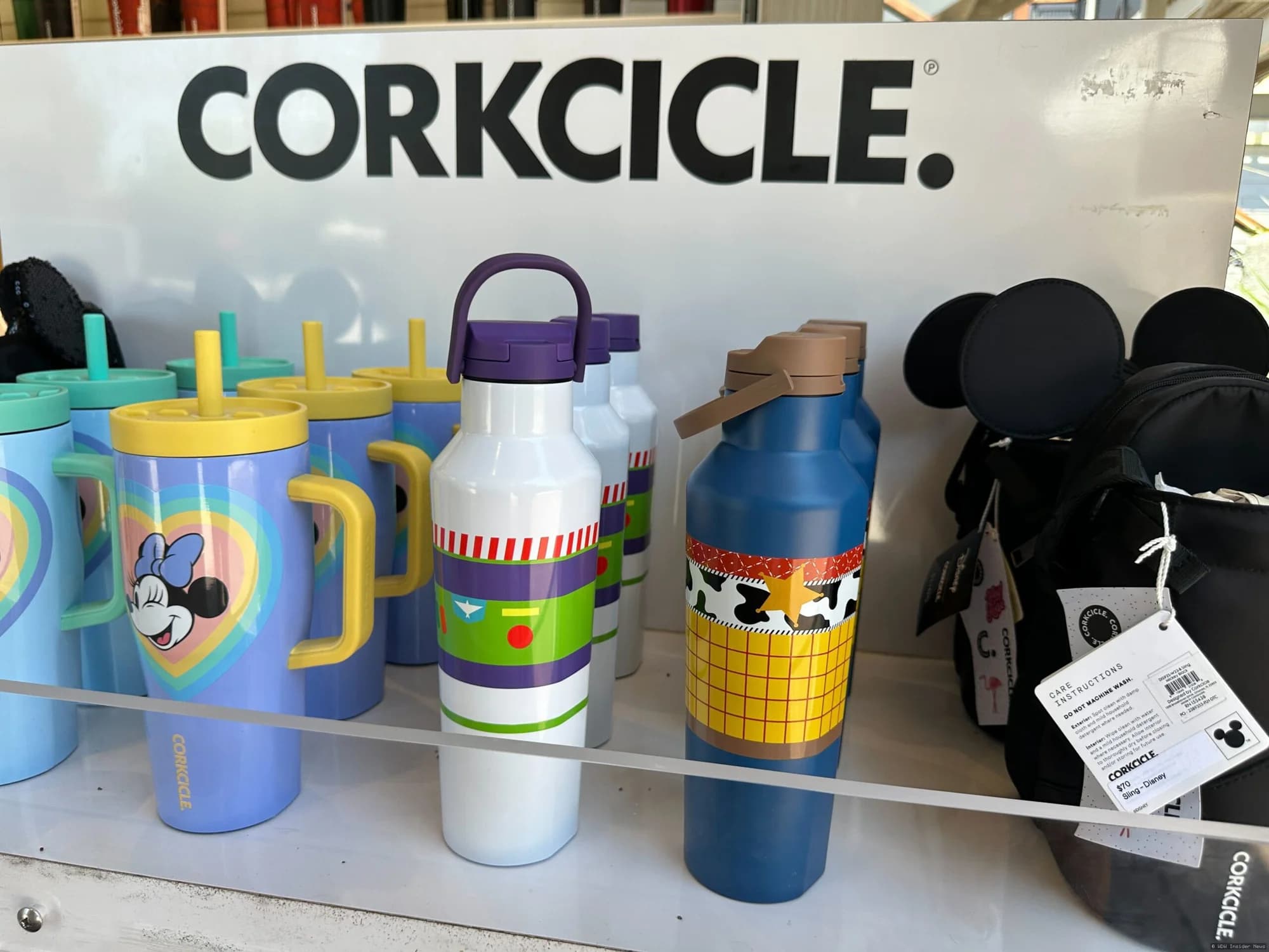 Woody and Buzz Lightyear character-themed Corkcicle insulated canteens displayed in a Disney Springs retail shop