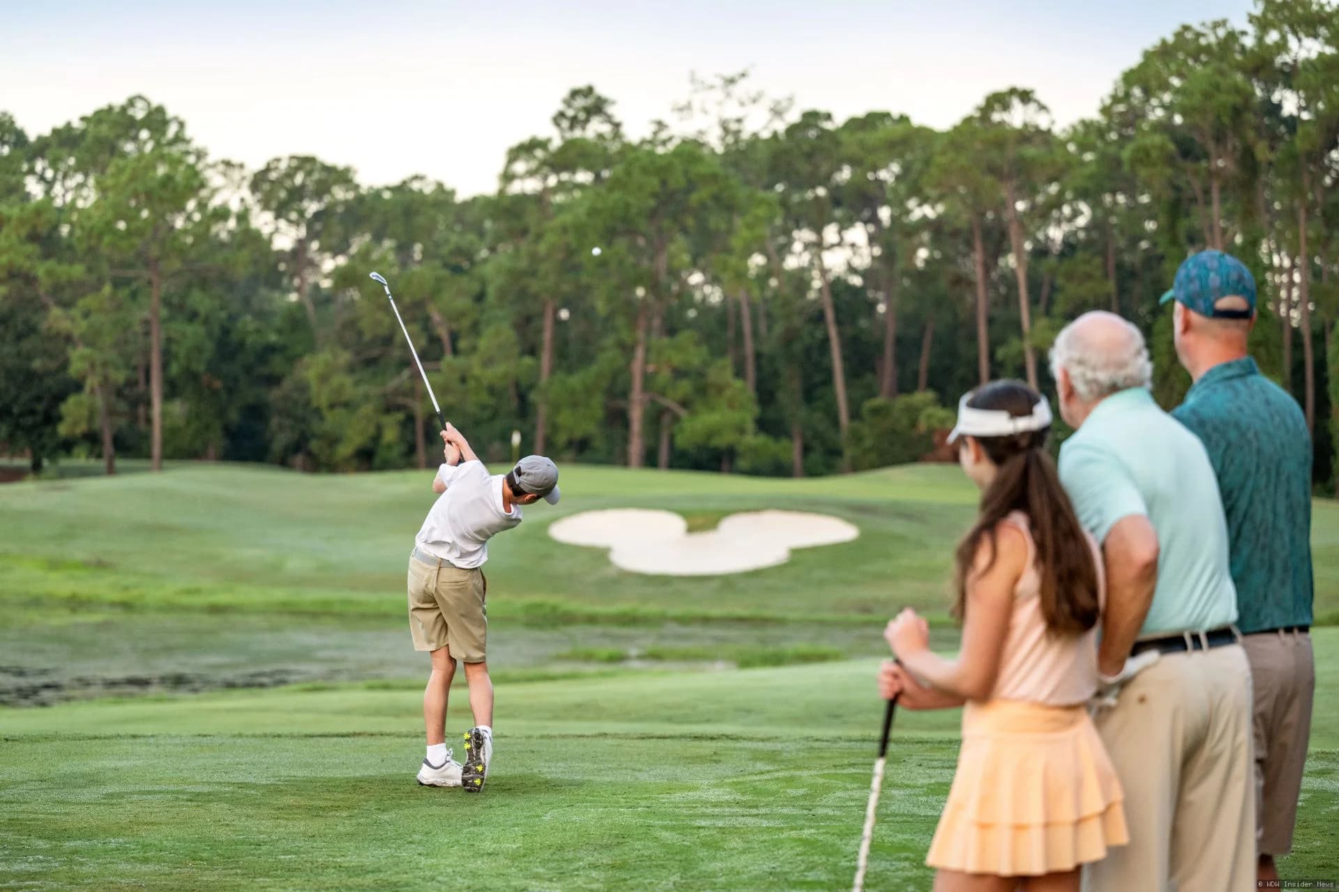 Four golfers playing on a lush green fairway at a Walt Disney World championship golf course