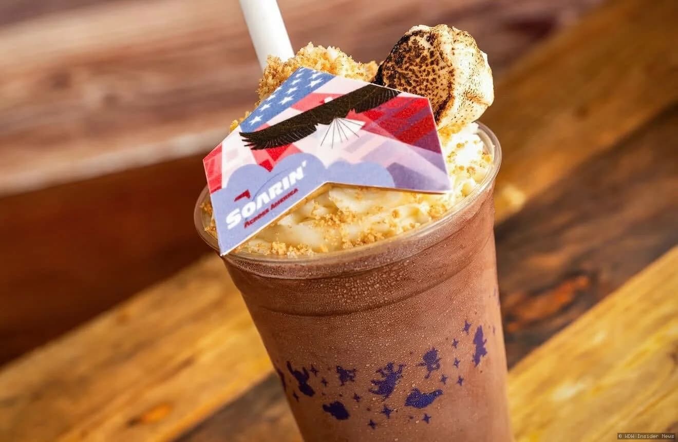 A creamy milkshake topped with toasted marshmallow and chocolate crumbles, served in a clear glass at EPCOT