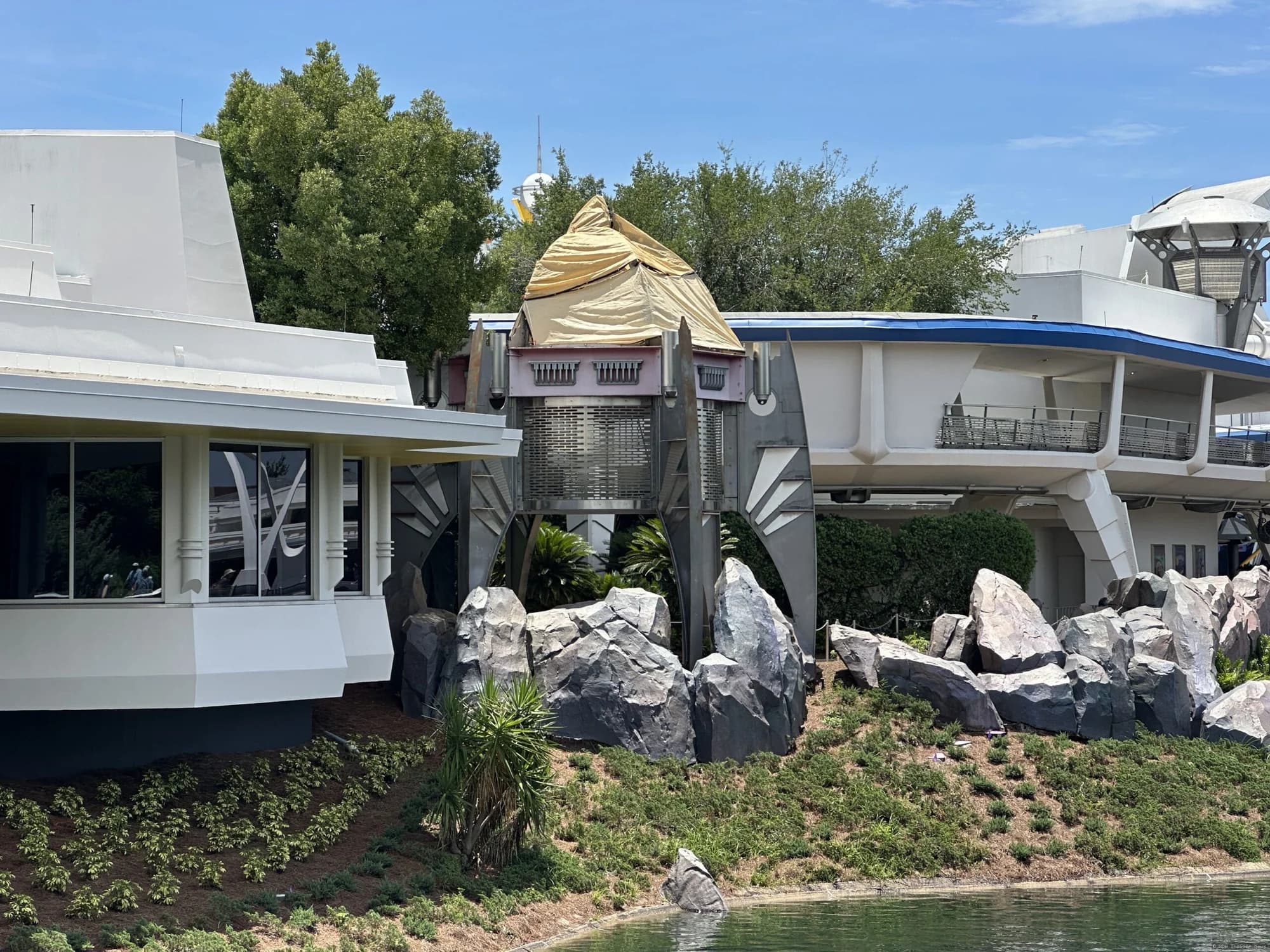 Demolition equipment removing a large futuristic tower structure in Tomorrowland at Magic Kingdom theme park