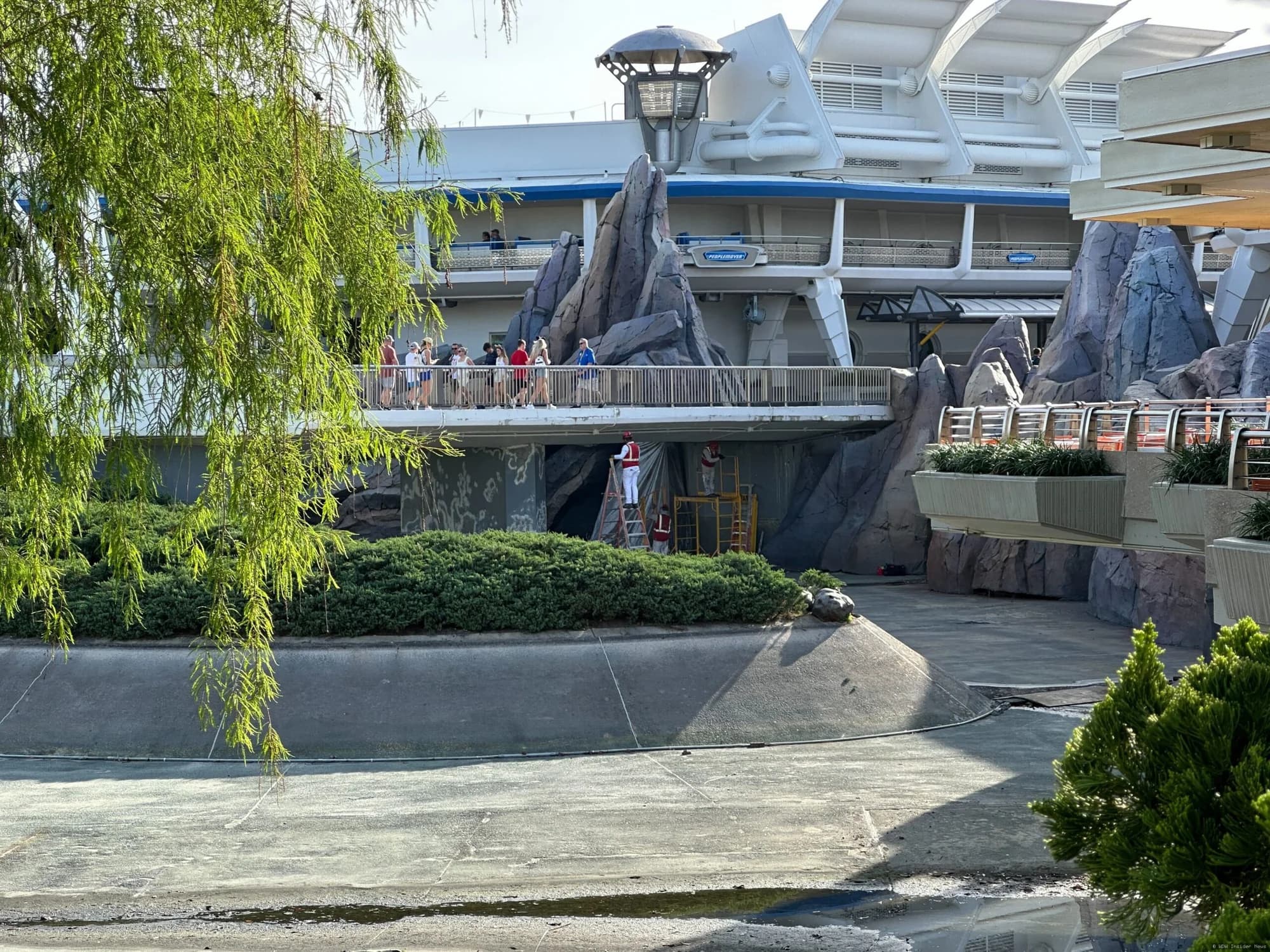 Cinderella Castle undergoing exterior painting and renovation work, with scaffolding visible around the base and bridge…