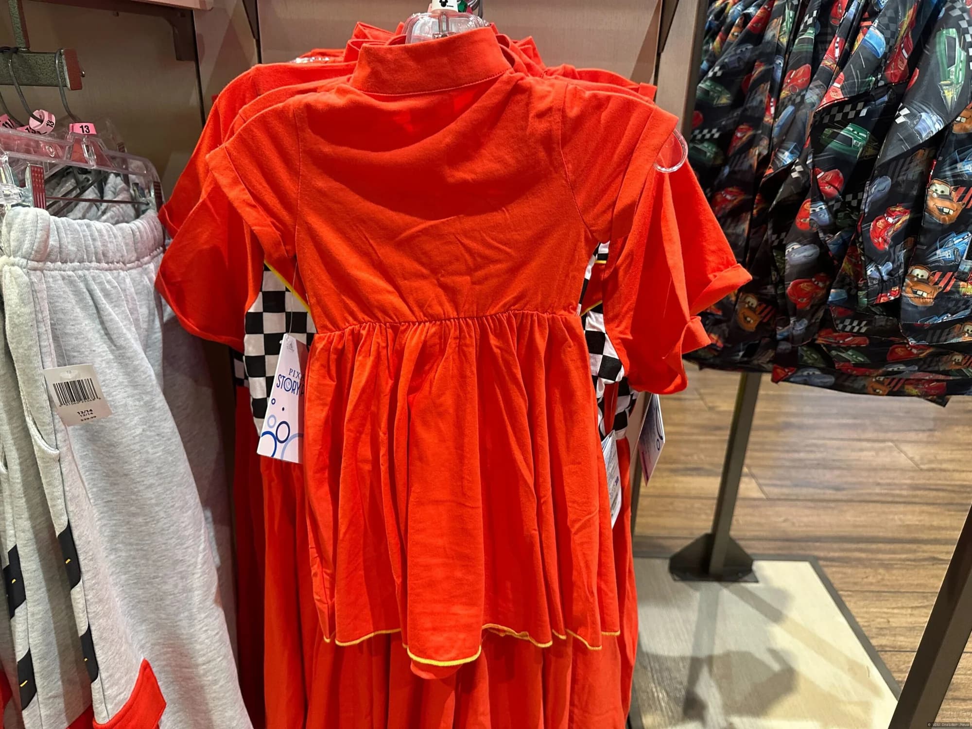 Lightning McQueen youth clothing displayed on mannequins or hanging in a Disney Springs or EPCOT retail shop