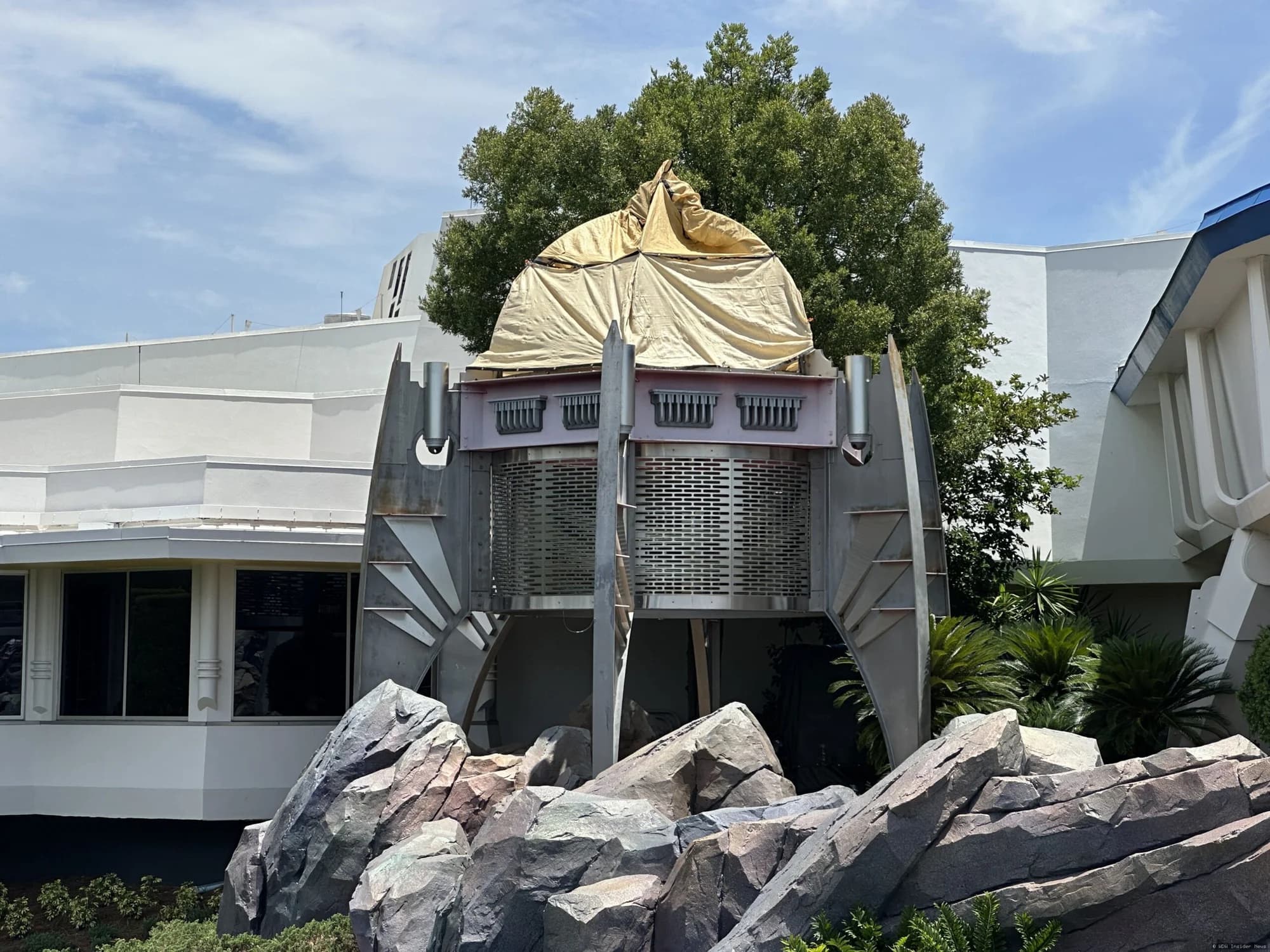 Demolition equipment removing a large futuristic tower structure in Tomorrowland at Magic Kingdom theme park