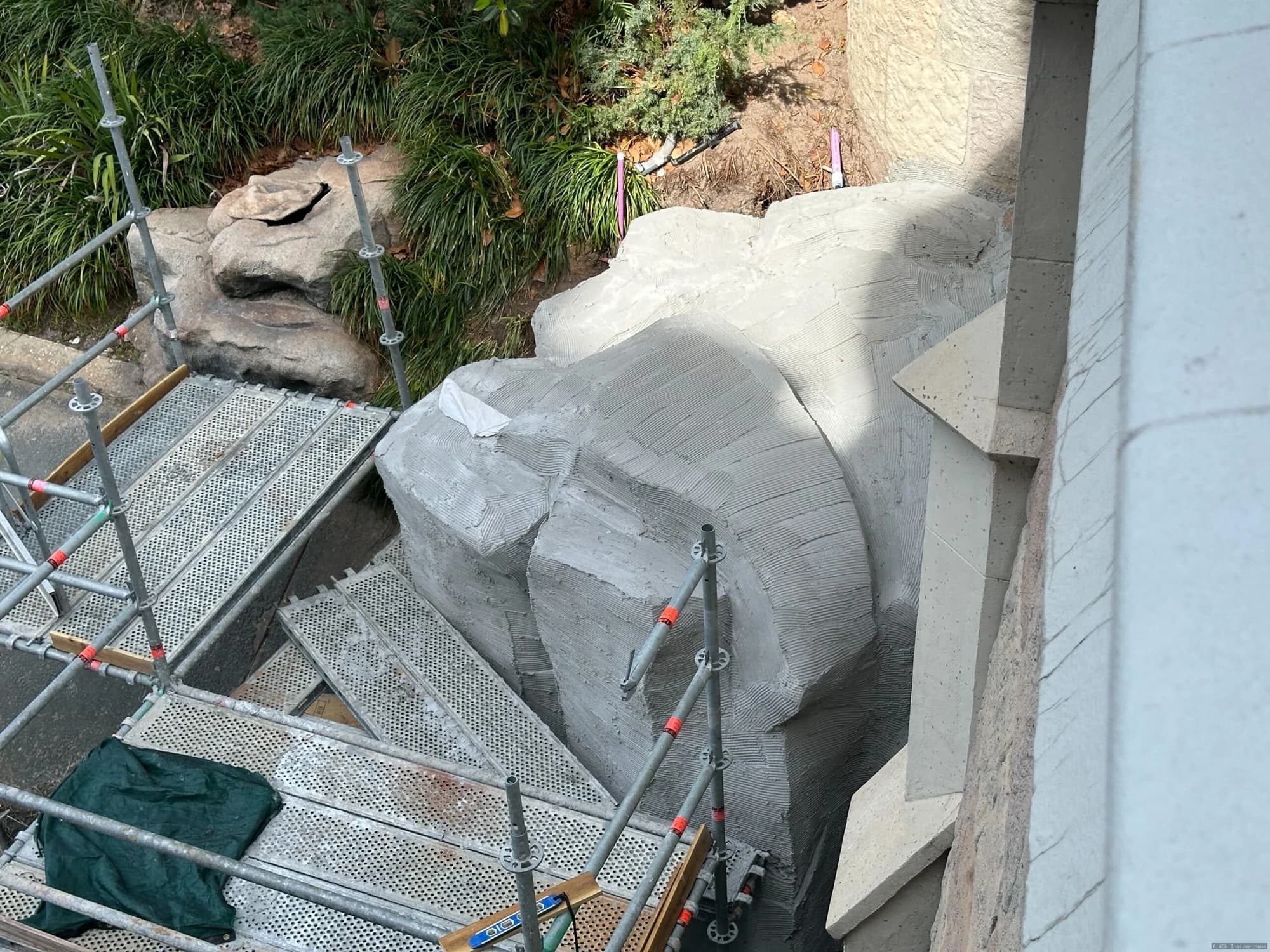 Cinderella Castle undergoing exterior painting and renovation work, with scaffolding visible around the base and bridge…