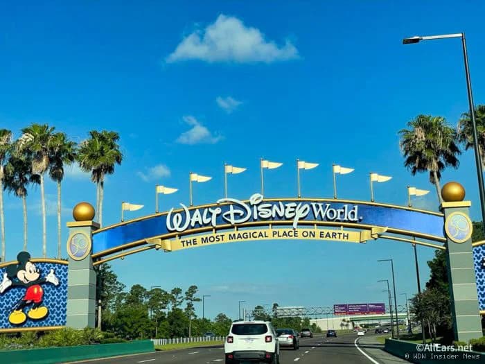 A Florida highway with directional signs pointing towards Walt Disney World, depicting a typical approach route to the…