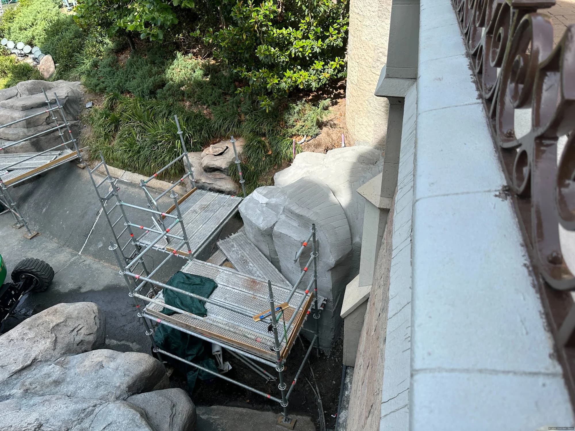 Cinderella Castle undergoing exterior painting and renovation work, with scaffolding visible around the base and bridge…